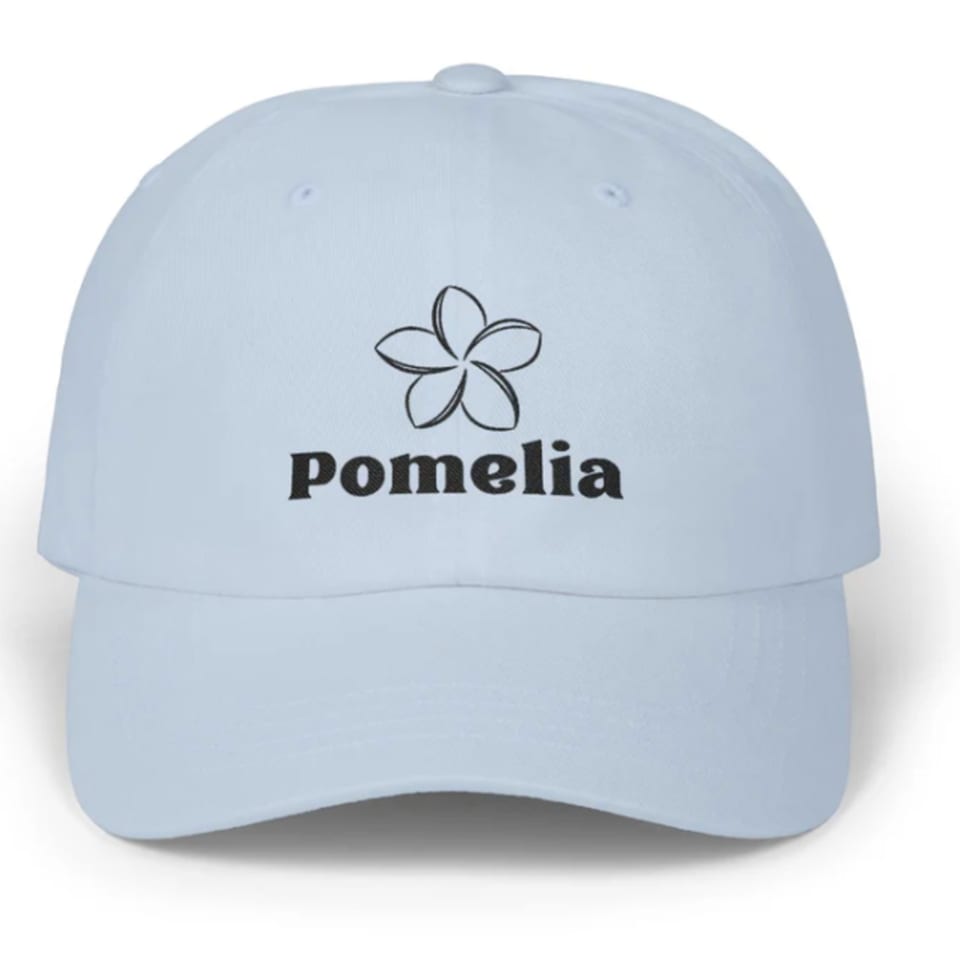 Light blue baseball cap with the Pomelia restaurant logo and name embroidered in black.