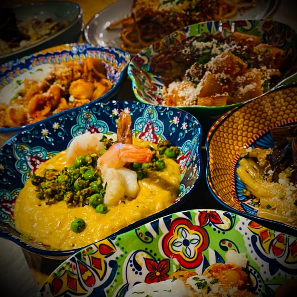 Assortment of colorful Italian pasta dishes, including shrimp with peas in a creamy sauce.
