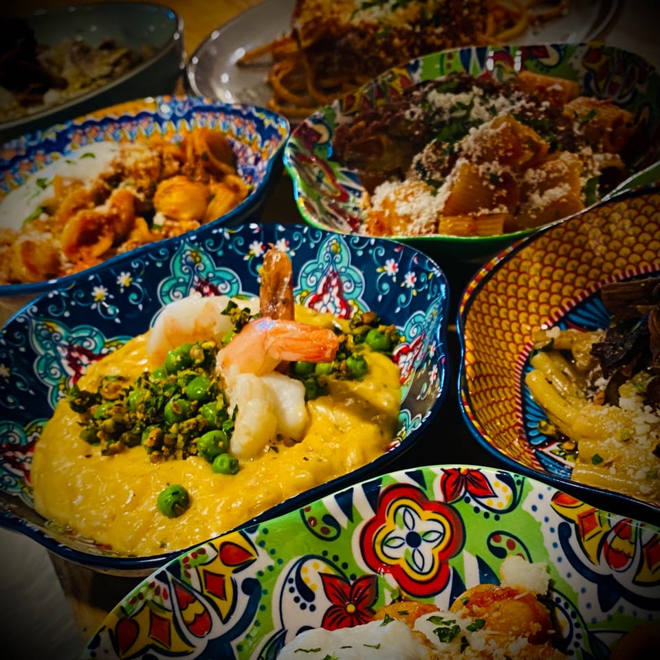 Assortment of colorful Italian pasta dishes, including shrimp with peas in a creamy sauce.